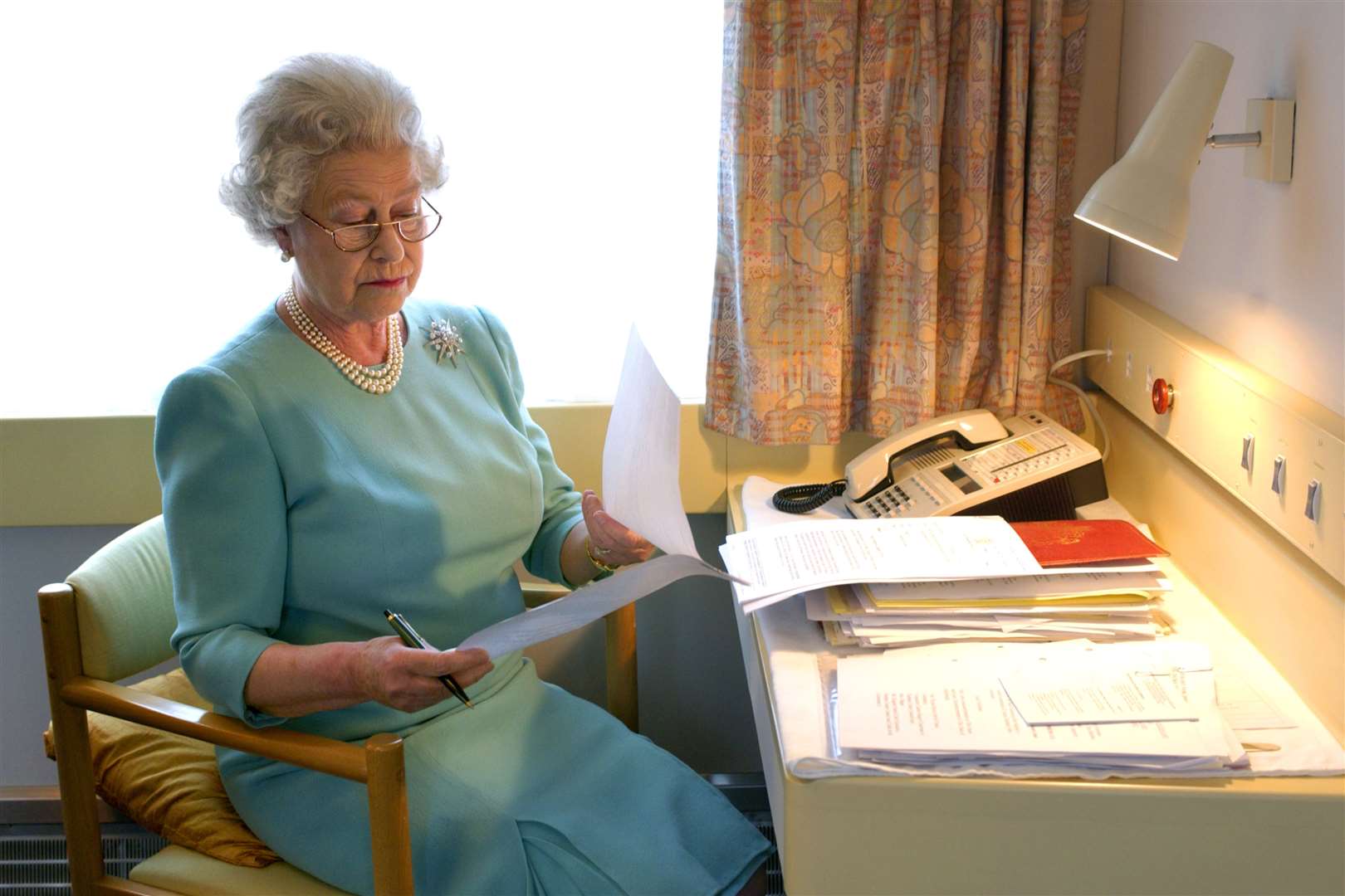 The Queen at work aboard the Royal Train in 2002 (Fiona Hanson/PA)