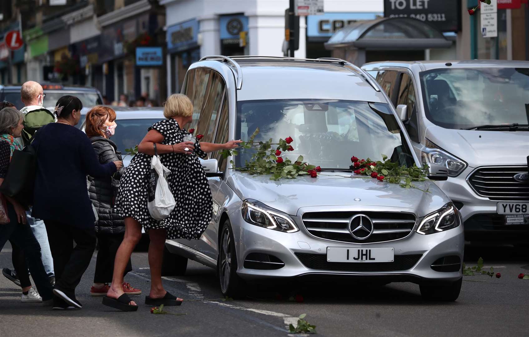 The roses were placed on the hearse as it passed by (Jane Barlow/PA)