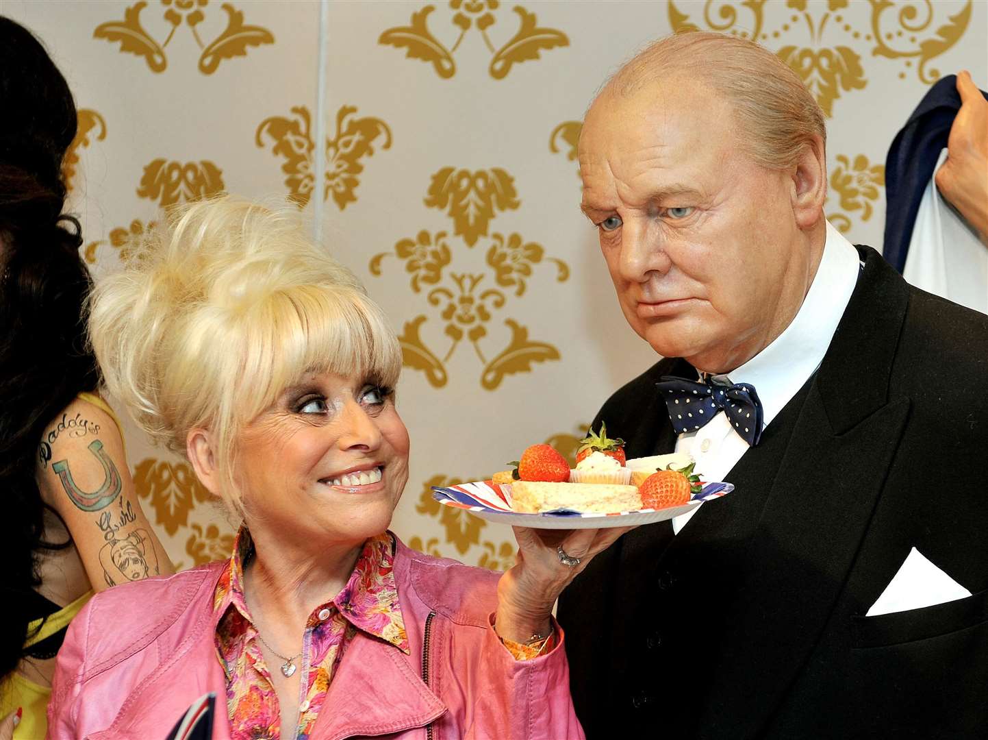 The TV star offers the wax figure of Sir Winston Churchill some lunch at Madame Tussauds in central London (John Stillwell/PA)