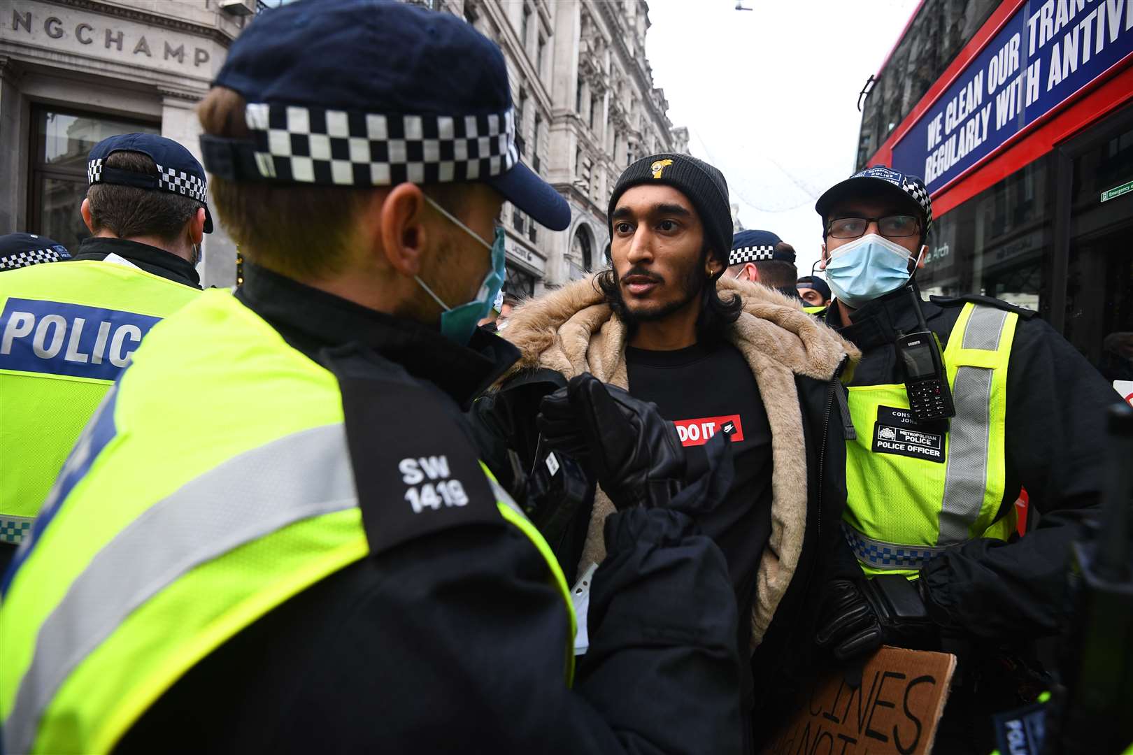 A man is detained during an anti-lockdown protest at Oxford Circus (Victoria Jones/PA)