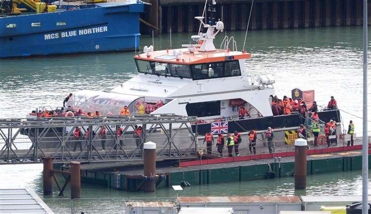 A group of people thought to be migrants are brought into Dover (PA)