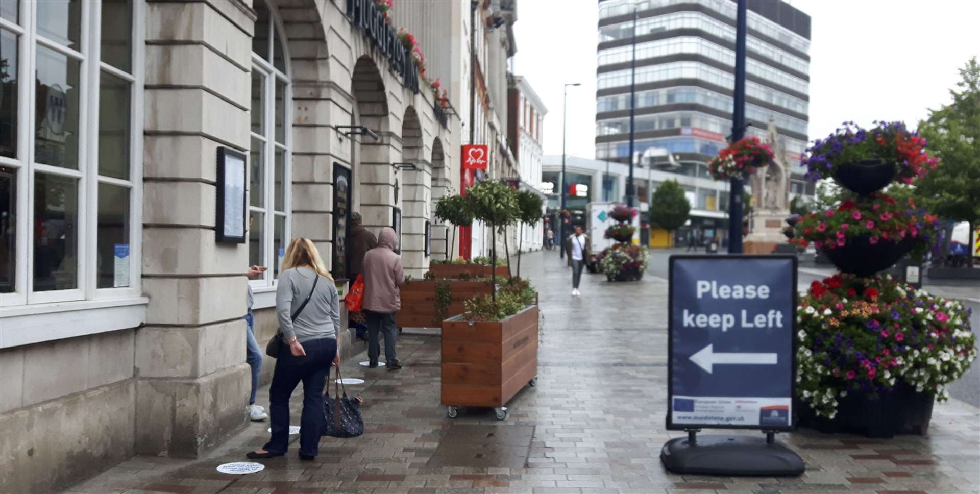 People waiting outside The Muggleton Inn in Maidstone for a Wetherspoons breakfast