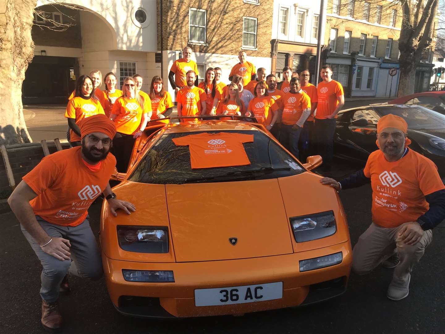 Monty Panesar (left) joins Kuflink founder Harwinder Binning and staff for Orange Day in aid of Muscular Dystrophy UK.