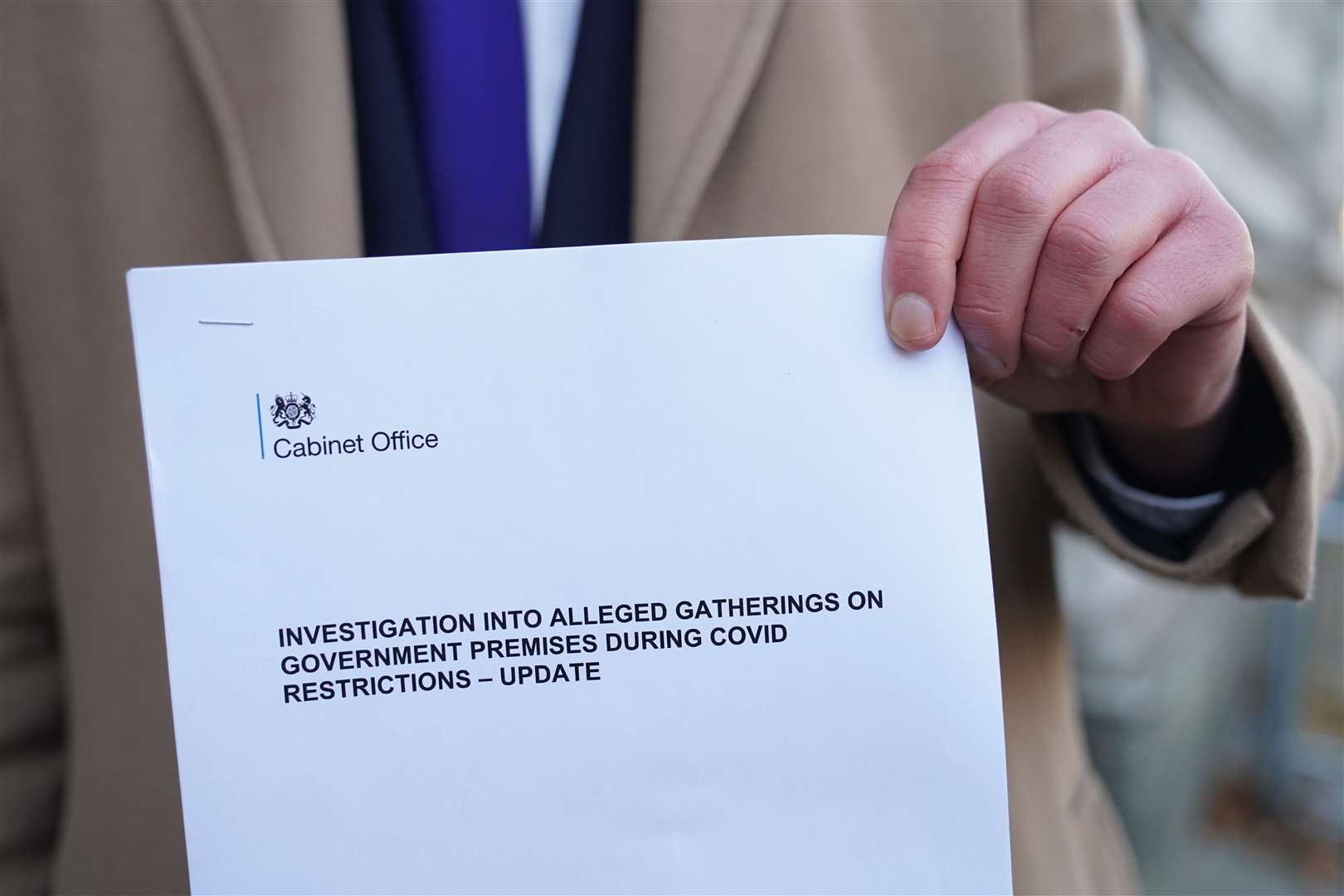 A man holds up a copy of the Sue Gray report in central London (Stefan Rousseau/PA)