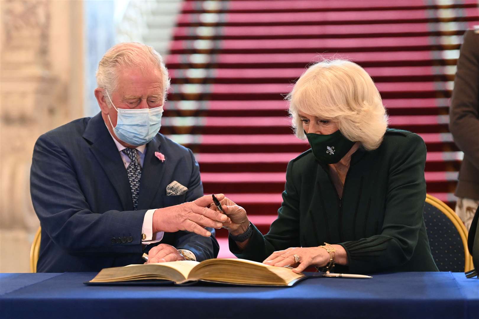 Charles and Camilla sign the visitors’ book at Belfast City Hall (Tim Rooke/PA)