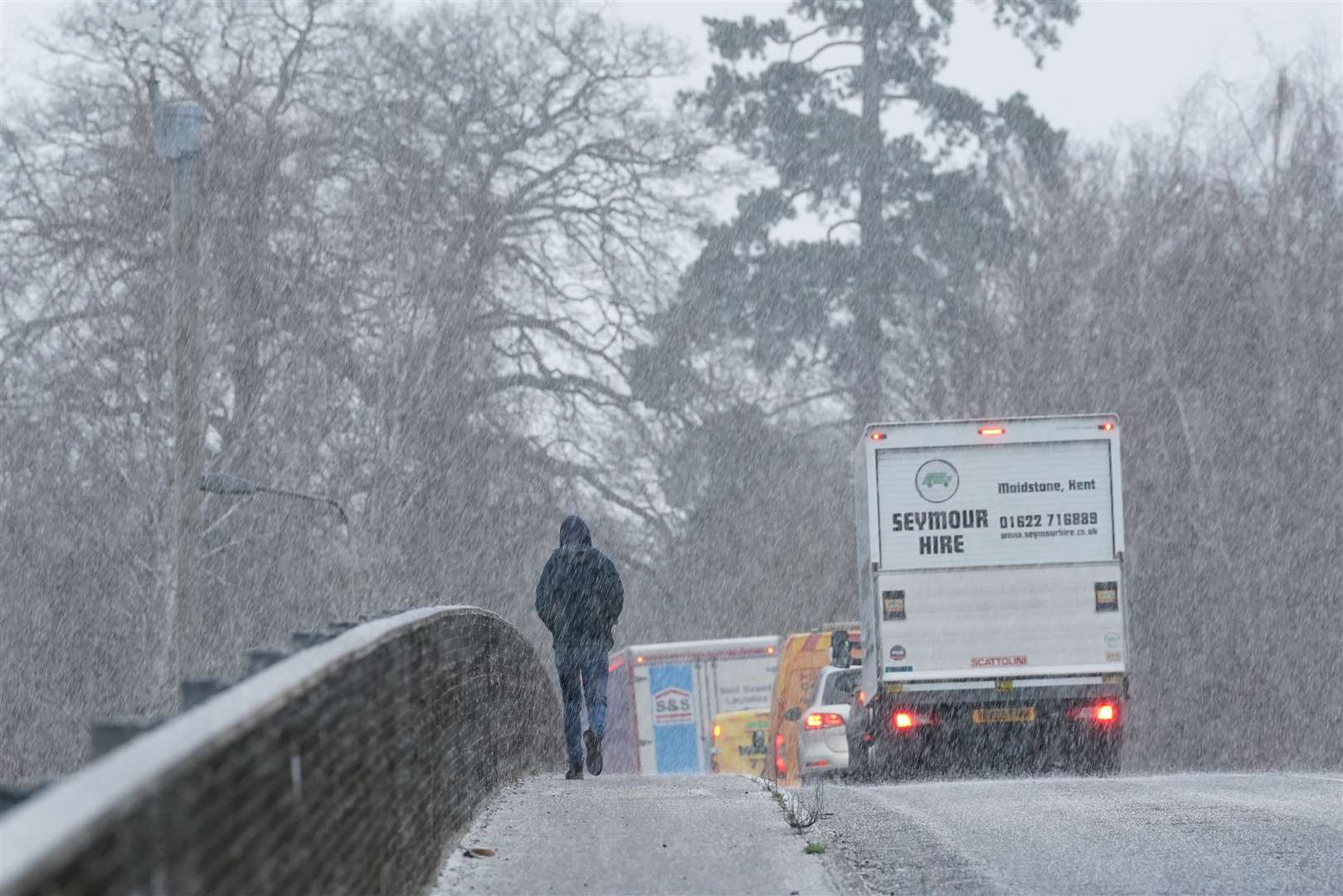 A pedestrian crosses a bridge during a snow shower near Maidstone in Kent (Gareth Fuller/PA)