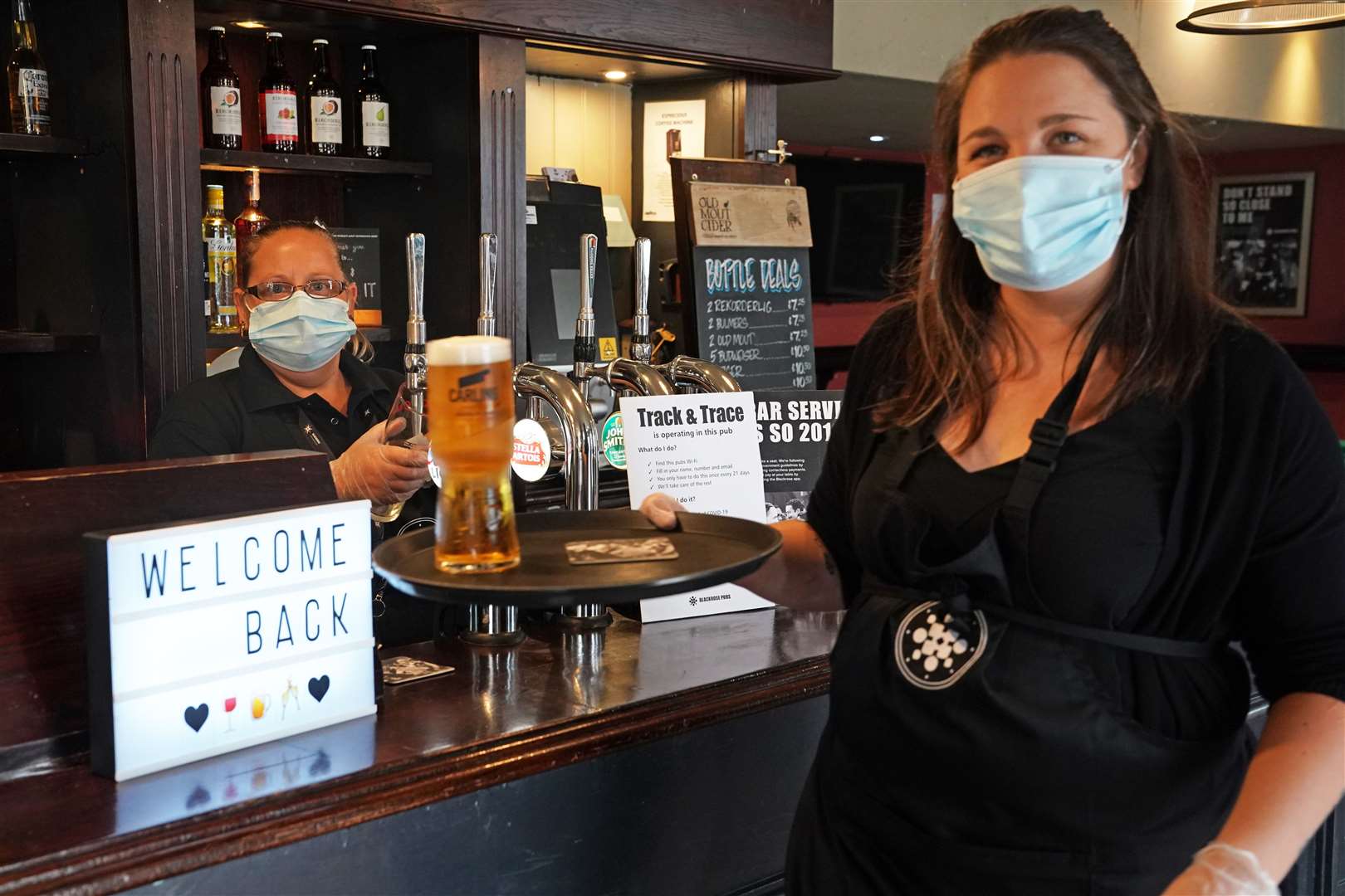 Staff wore PPE after pubs reopened last summer following the first lockdown (Owen Humphreys/PA)