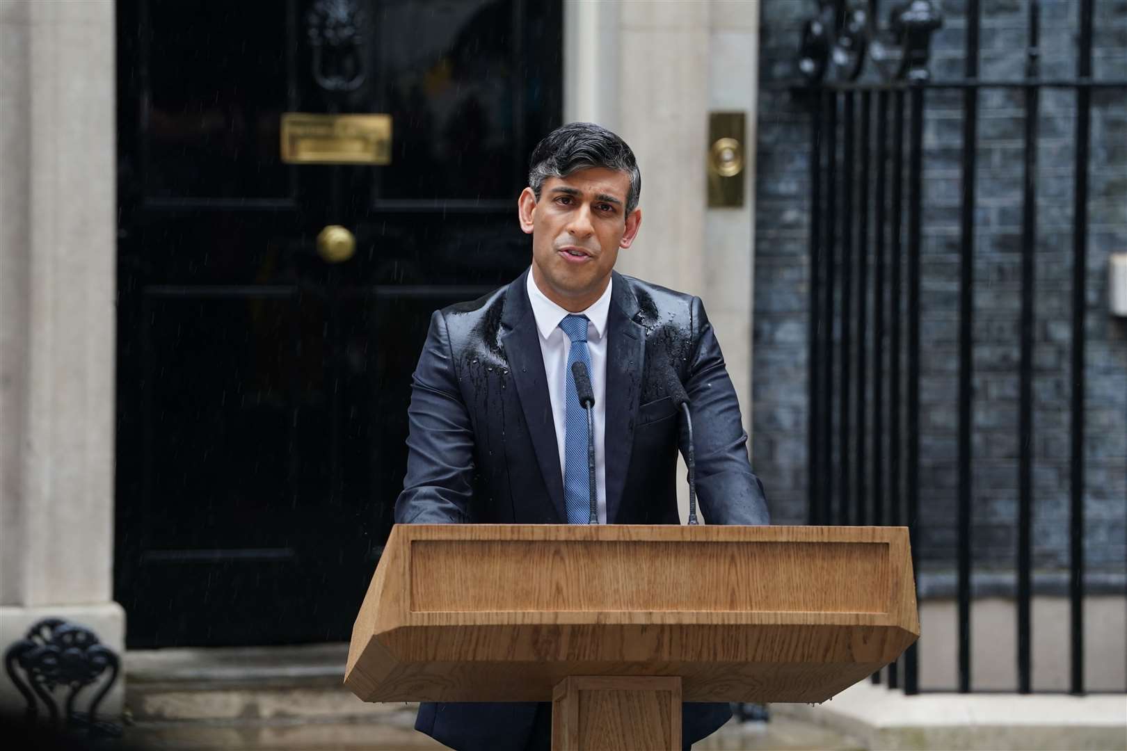 The most memorable political image of the year is probably Rishi Sunak soaked in rain as he announced the general election outside Downing Street (Lucy North/PA)