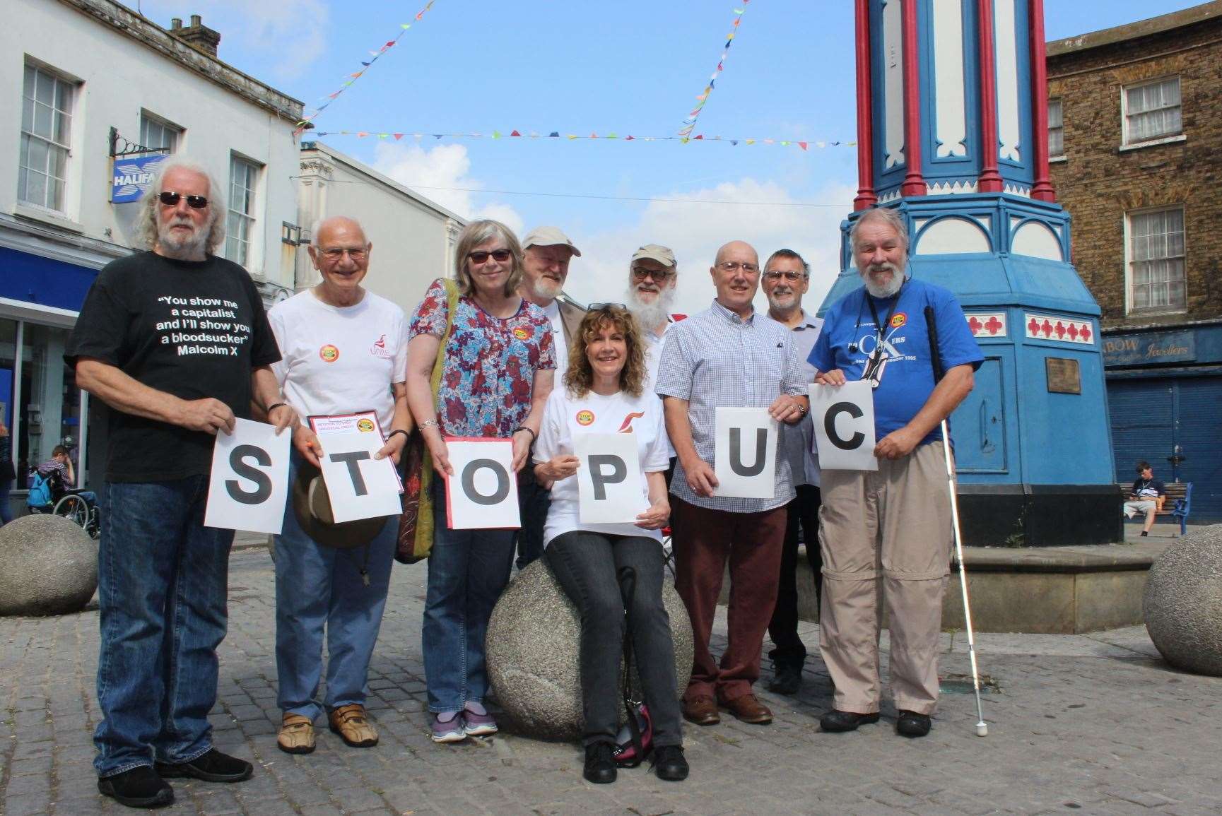 Helen Martins, seated, with members of Unite Community protesting about Universal Credits at Sheerness clock tower. Picture: John Nurden