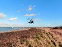 Kent Air Ambulance coming in to land on the sea wall along the Saxon Shore Way close to Upchurch