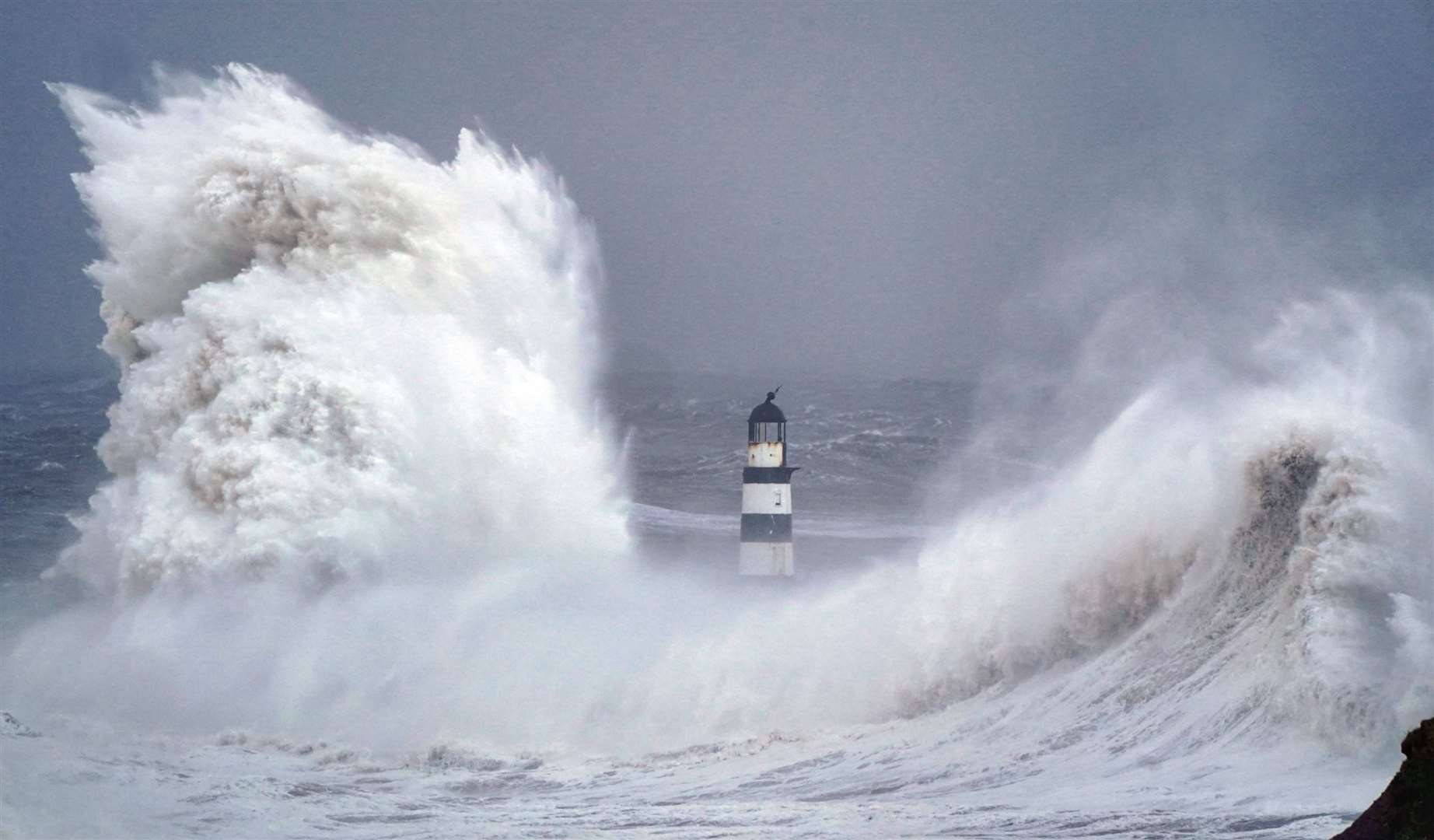 Huge waves crash against the lighthouse in Seaham Harbour, County Durham (Owen Humphreys/PA)