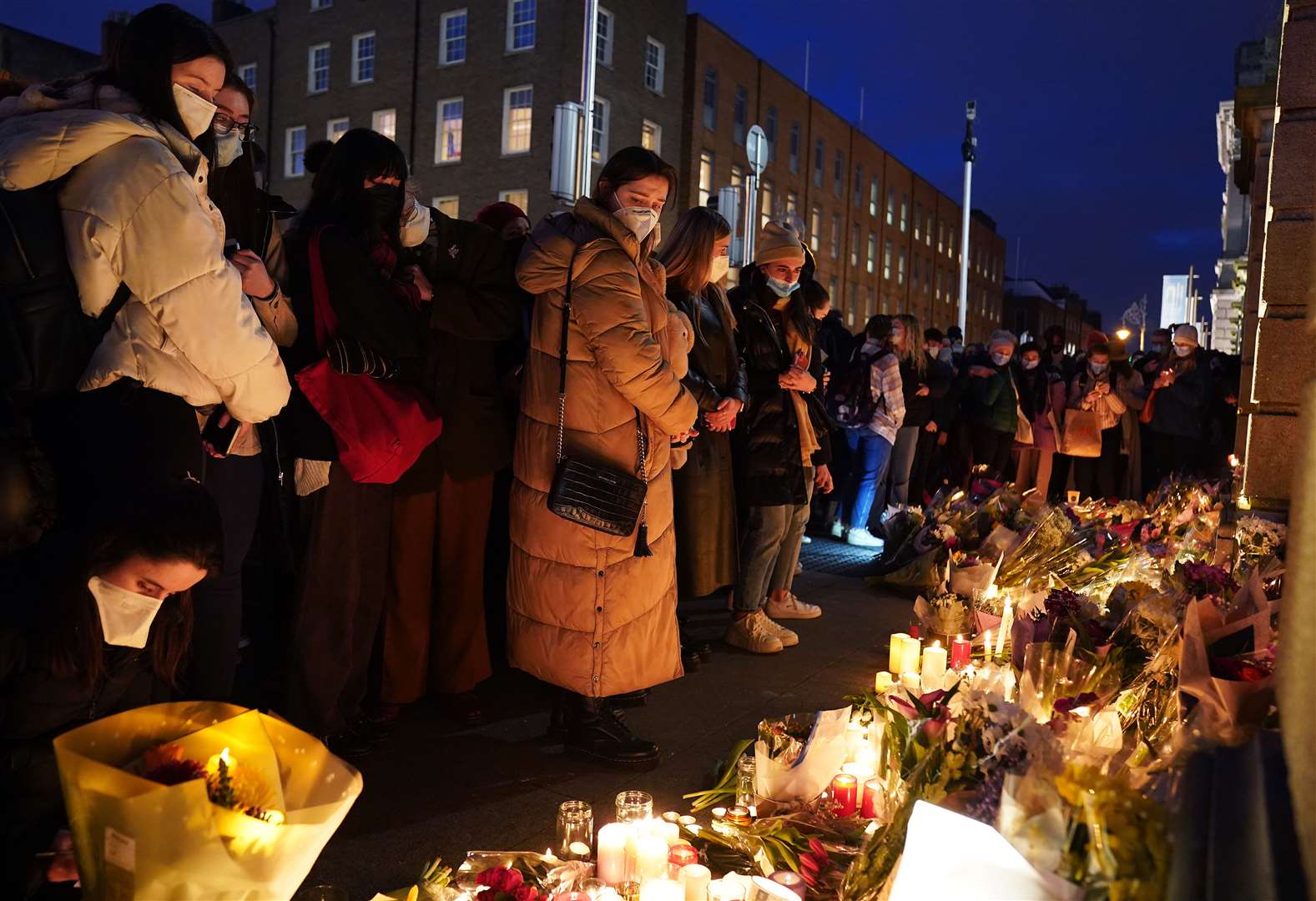 People leave candles and flowers at a makeshift shrine in Ms Murphy’s honour during a vigil at Leinster House, Dublin (Brian Lawless/PA)