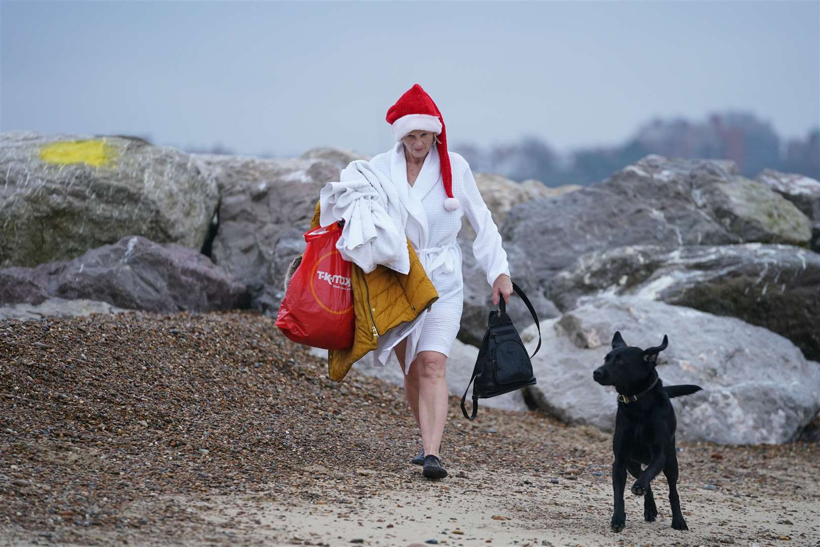 Dressed for the occasion… a woman walks along the beach (Joe Giddens/PA)