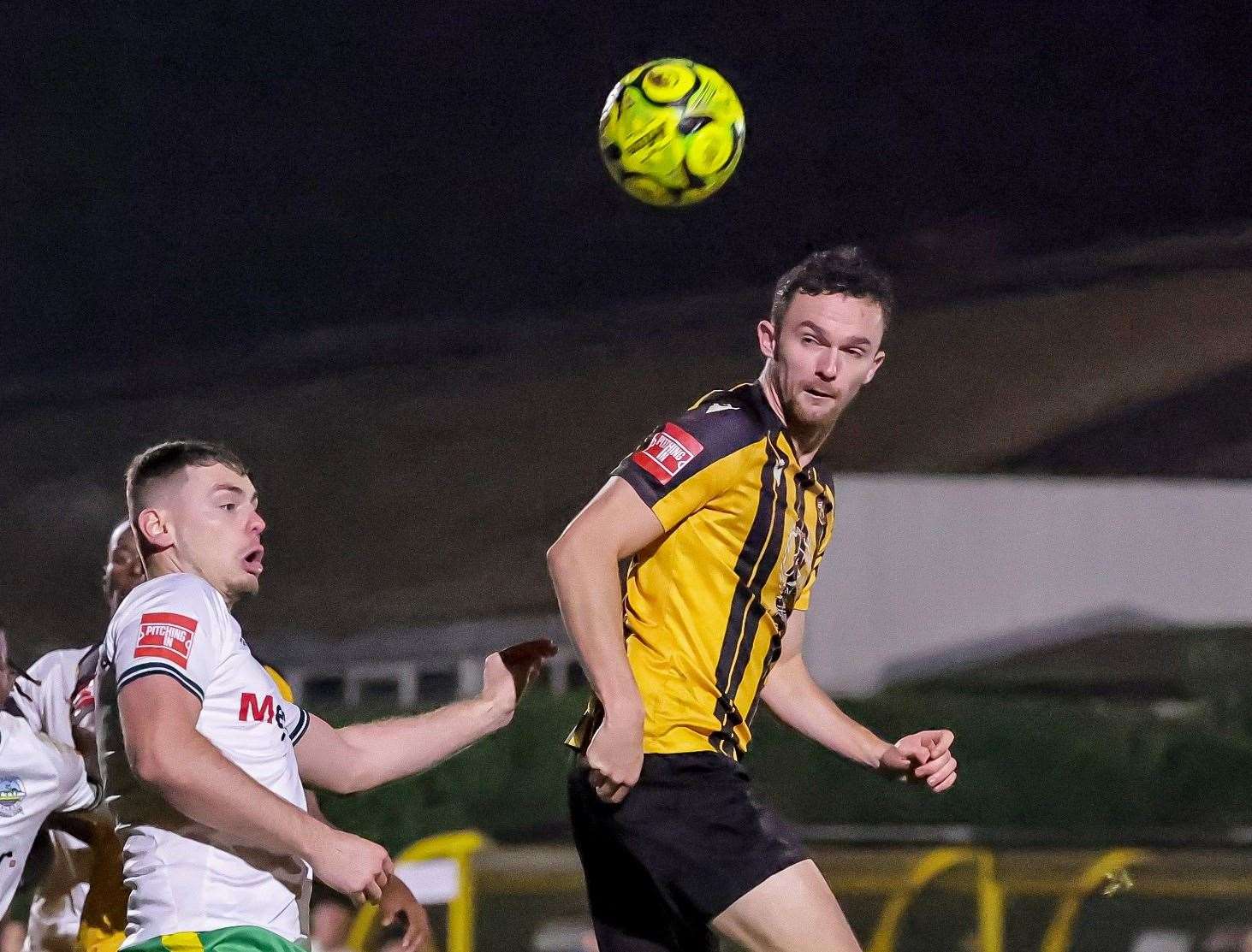 Folkestone forward Dan Smith heads the ball ahead of Dover defender Luca Cocoracchio - before Smith was red-carded - in Invicta’s 1-0 Isthmian Premier loss on Tuesday night. Picture: Helen Cooper