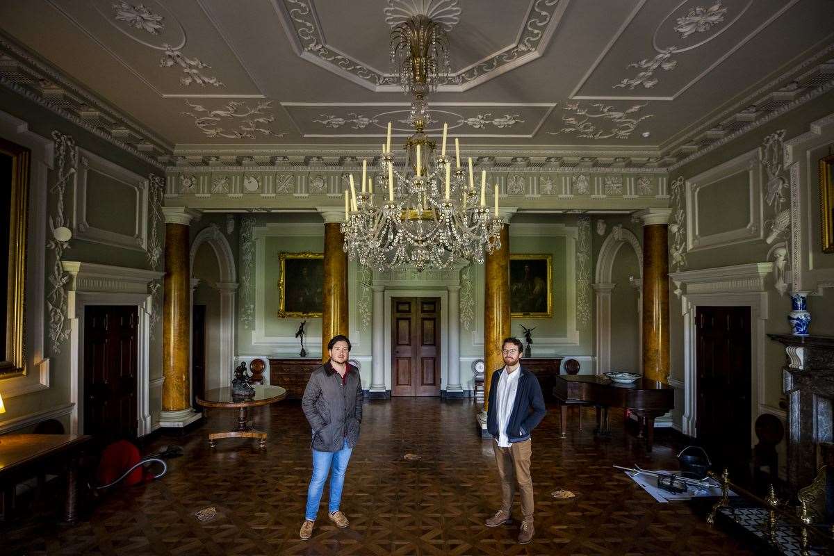 Neil Watt (left) with his partner Kris Reid standing under the chandelier in Castle Ward’s reception hall which they cleaned during the pandemic (Liam McBurney/PA)