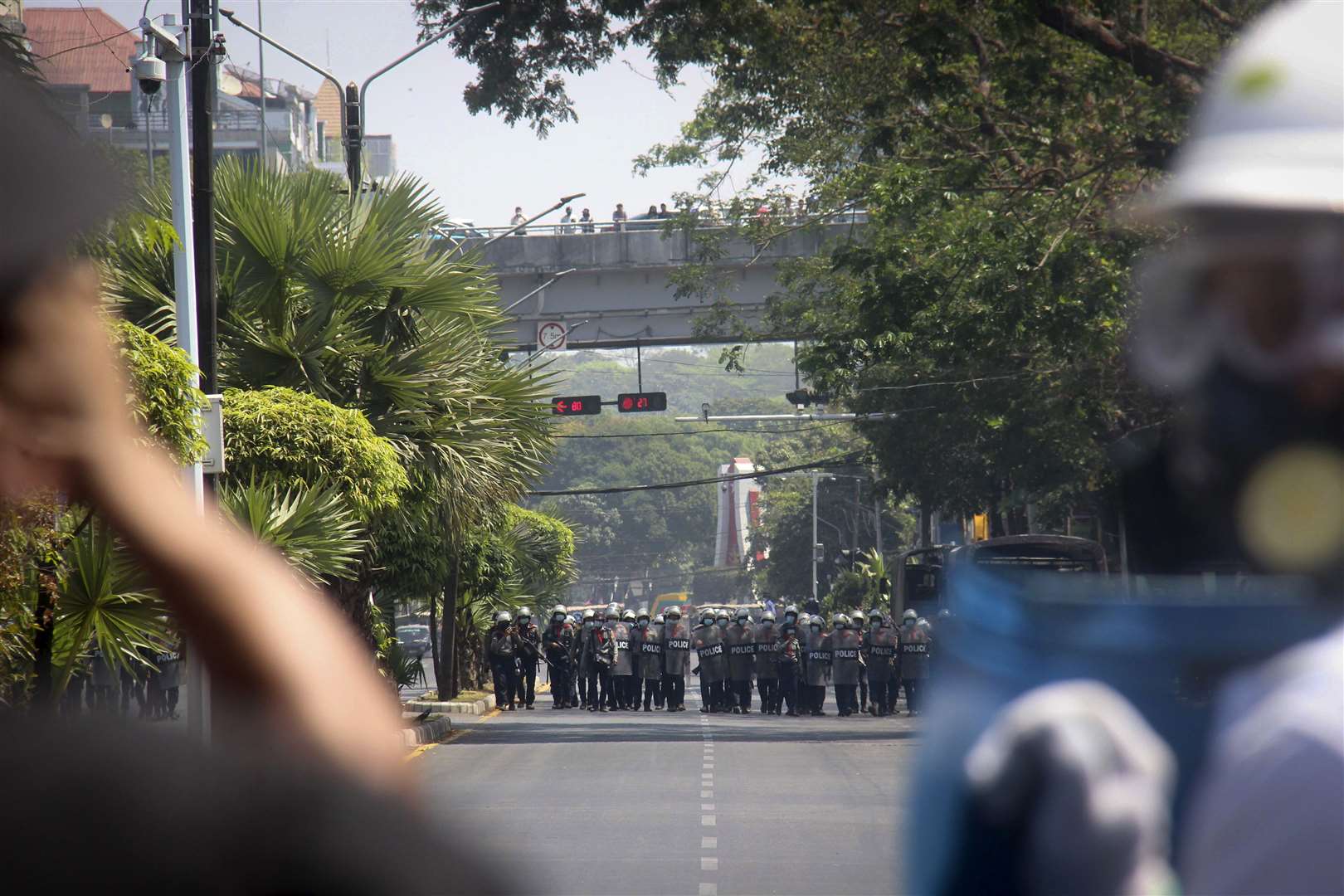 Protesters watch as police are deployed during an anti-coup protest march in Yangon, Myanmar, on Monday (AP Photo)