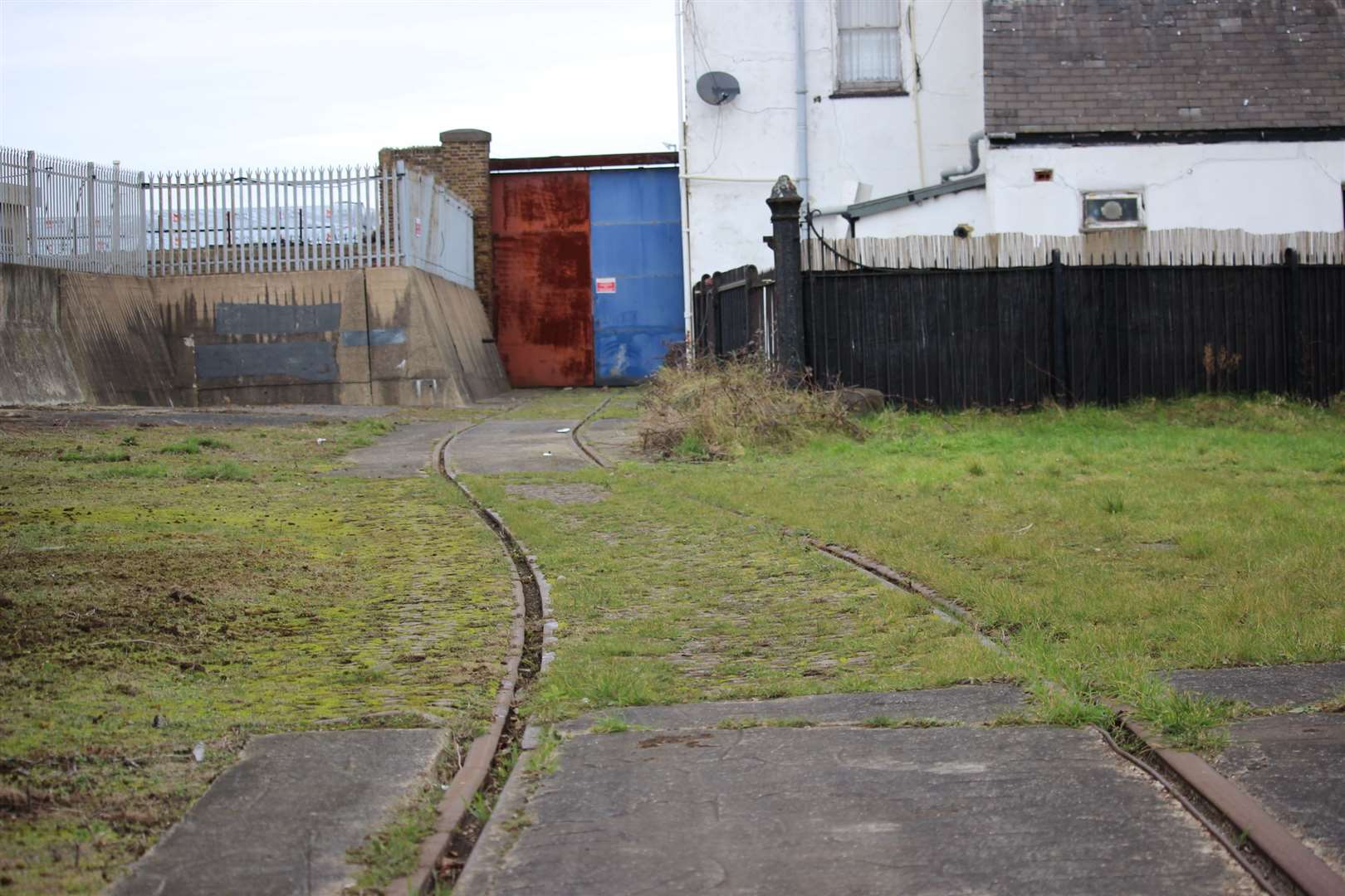 Now: rail tracks remain going into Sheerness Docks through a gap in the wall at Blue Town