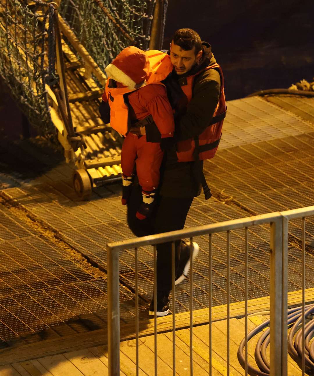 Another toddler carried by a man after the rescue. Picture UKNIP