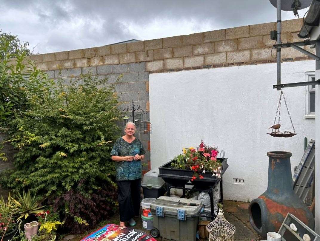 Allyson Halls in her bungalow garden in London Road, West Kingsdown, next to the 'prison wall'