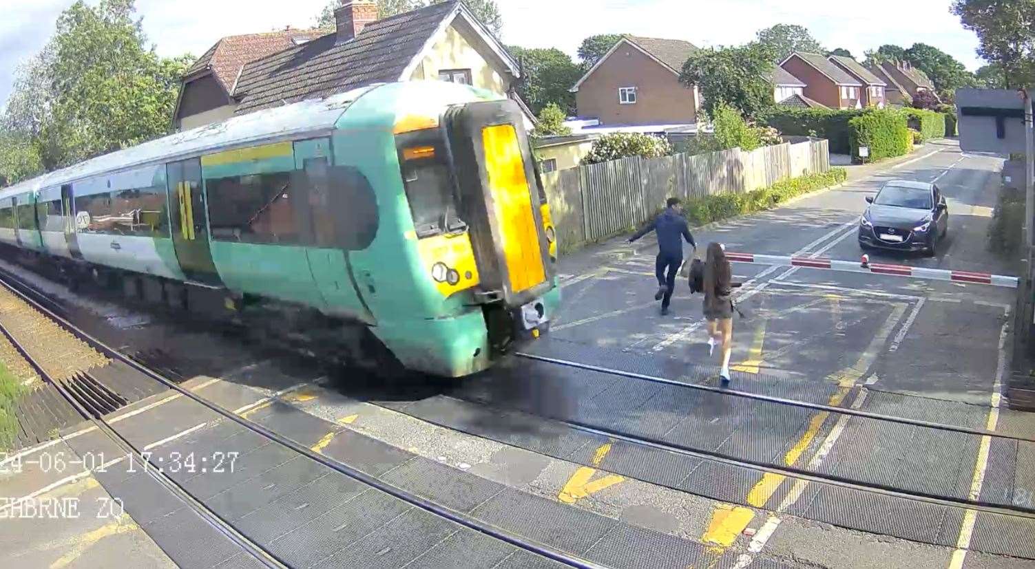 A couple dashing across the railway is among the footage in the Network Rail Southern region level crossing safety campaign. Picture: Network Rail