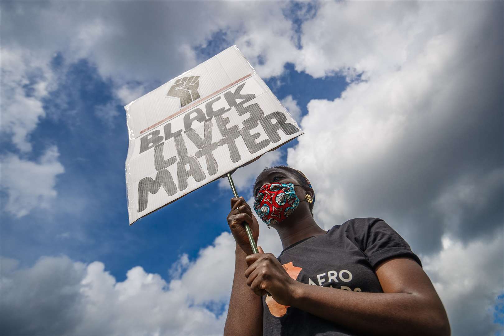 A woman holds a banner during a Black Lives Matter protest rally at Woodhouse Moor in Leeds (Danny Lawson/PA)