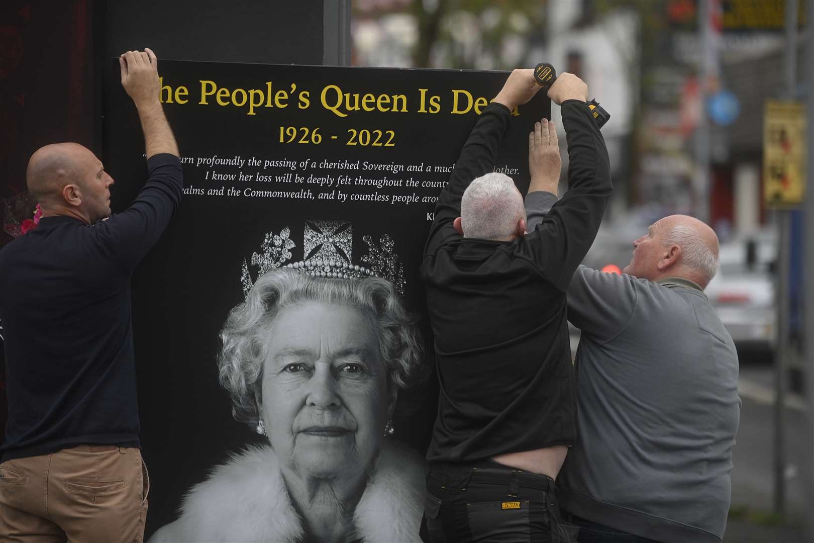 Council workers and local community representatives hang a mural on a wall on Crimea street off the Shankill road in Belfast (Mark Marlow/PA)