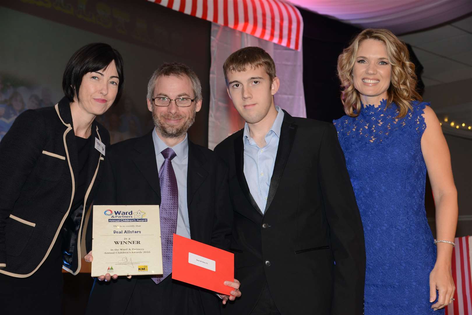 Charlotte Hawkins and Operations Director of Ward & Partners Sam Dalton present the award for Charity of the Year to Coach Steven Chapman and one of his players, Hayden Giles from Allstars FC