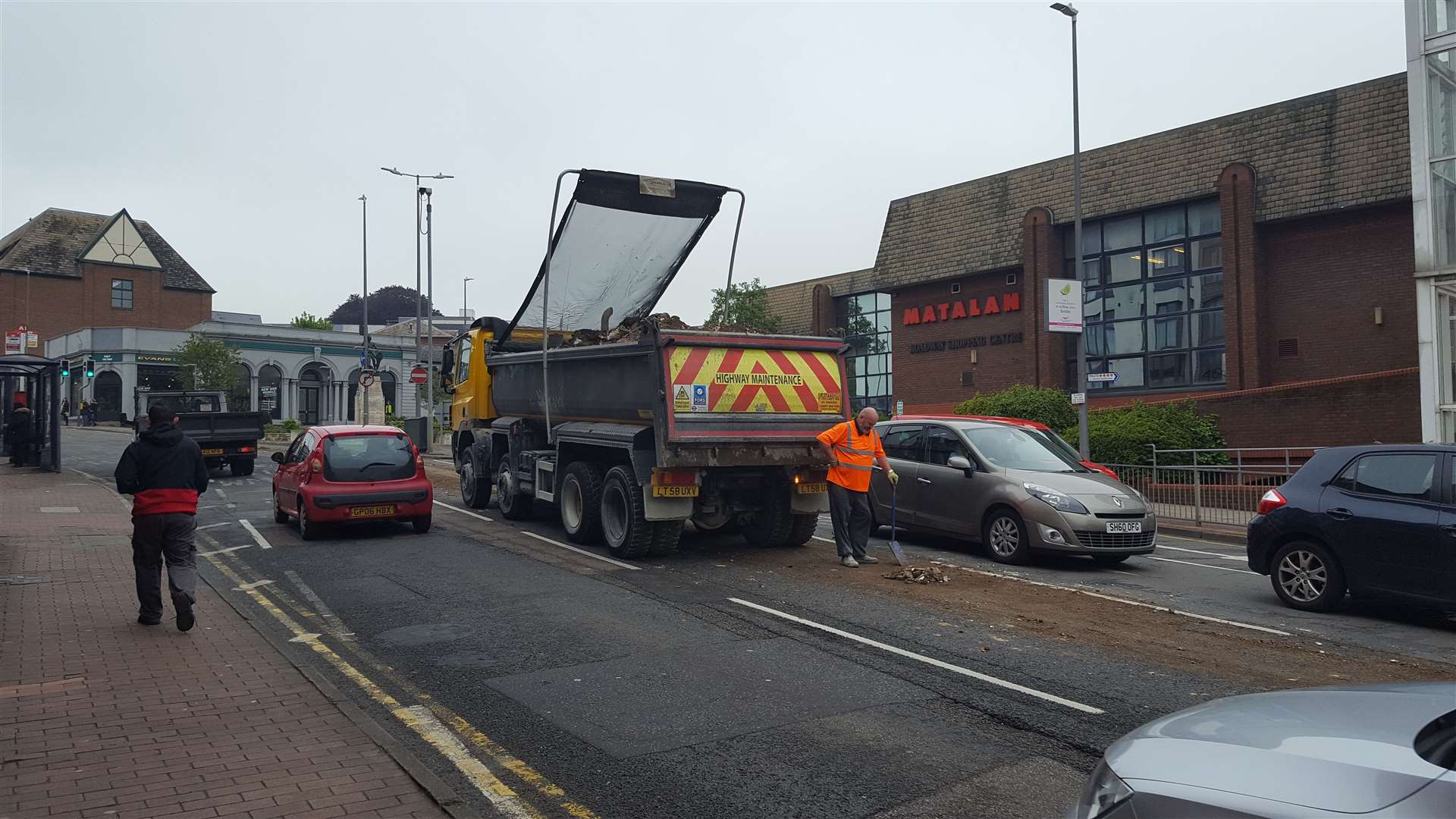 The driver, exhausted from shovelling, stood by the lorry before heaving the last bits of the load