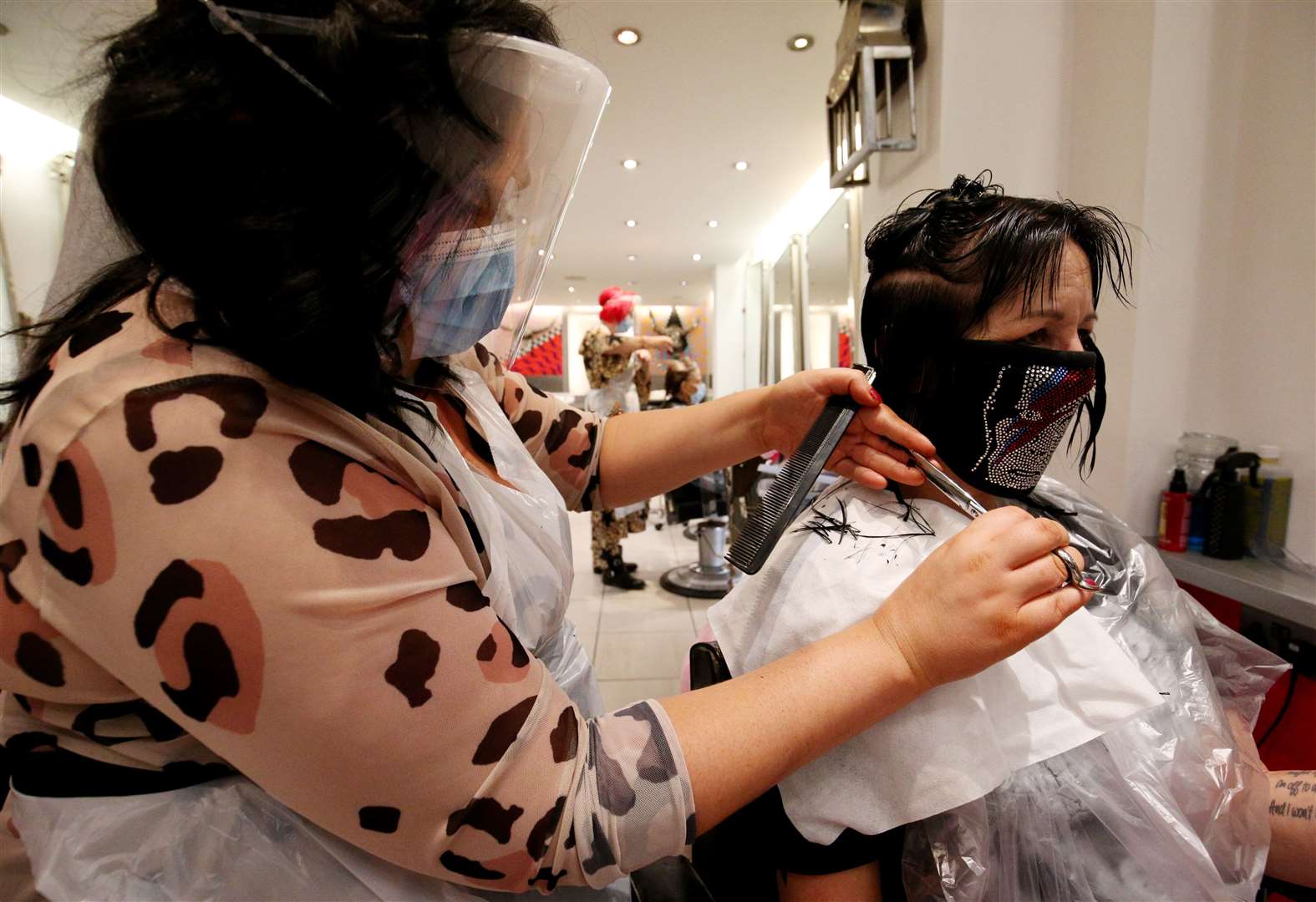 Stylist Hayley Hehir (left) cuts the hair of client Francesca Shashkova (right) at Tusk Hair in Camden (Jonathan Brady/PA)