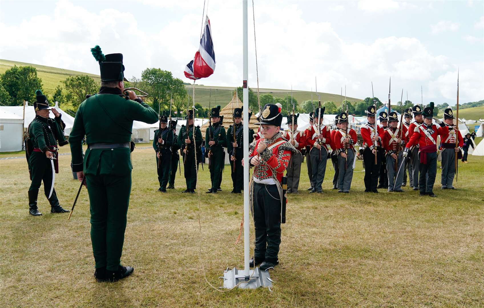 Members of the 4th King’s Own Regiment of Foot and 2nd Battalion 9th Rifles stand to attention as a Union flag is raised (Andrew Matthews/PA)