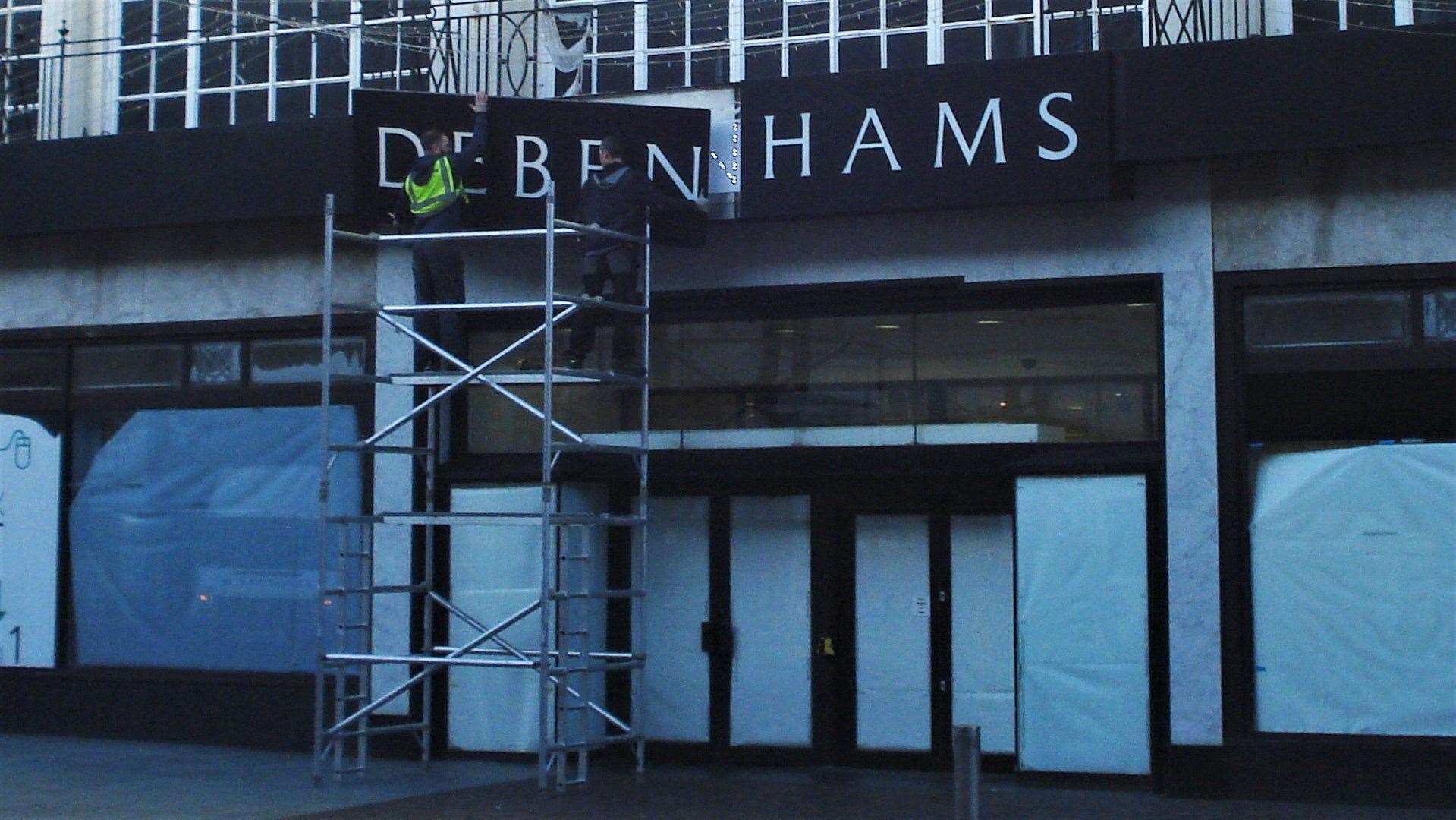 Workers remove the Debenhams sign at the Folkestone store in January this year - the shop has been empty ever since. Picture credit: Legends of Folkestone Facebook page