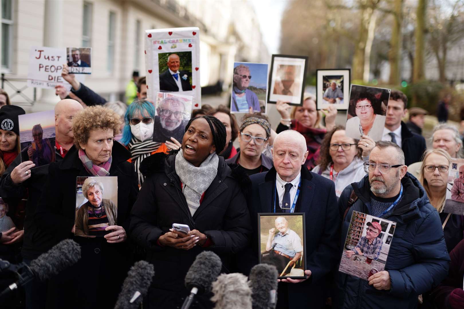 Members of Covid Bereaved England, holding photographs of their relatives who died in the pandemic, outside a hearing of the inquiry (Jordan Pettitt/PA)