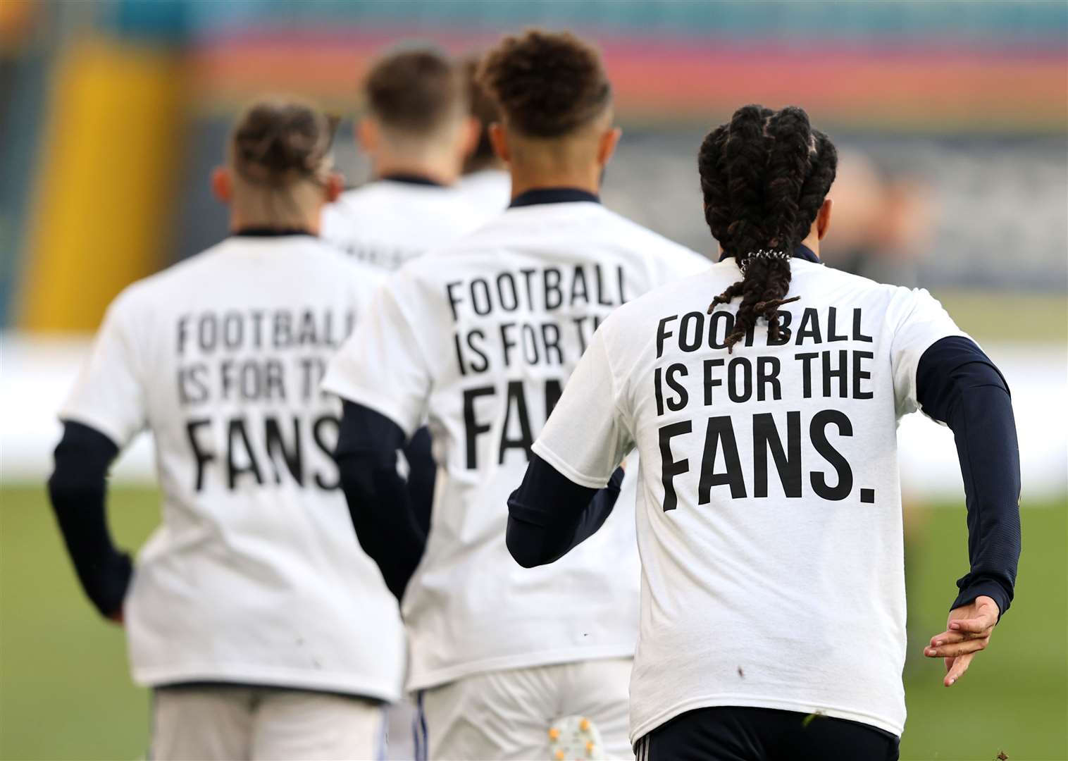 Leeds players wearing ‘Football Is For The Fans’ shirts during the warm up for their Premier League match with Liverpool (Clive Brunskill/PA)