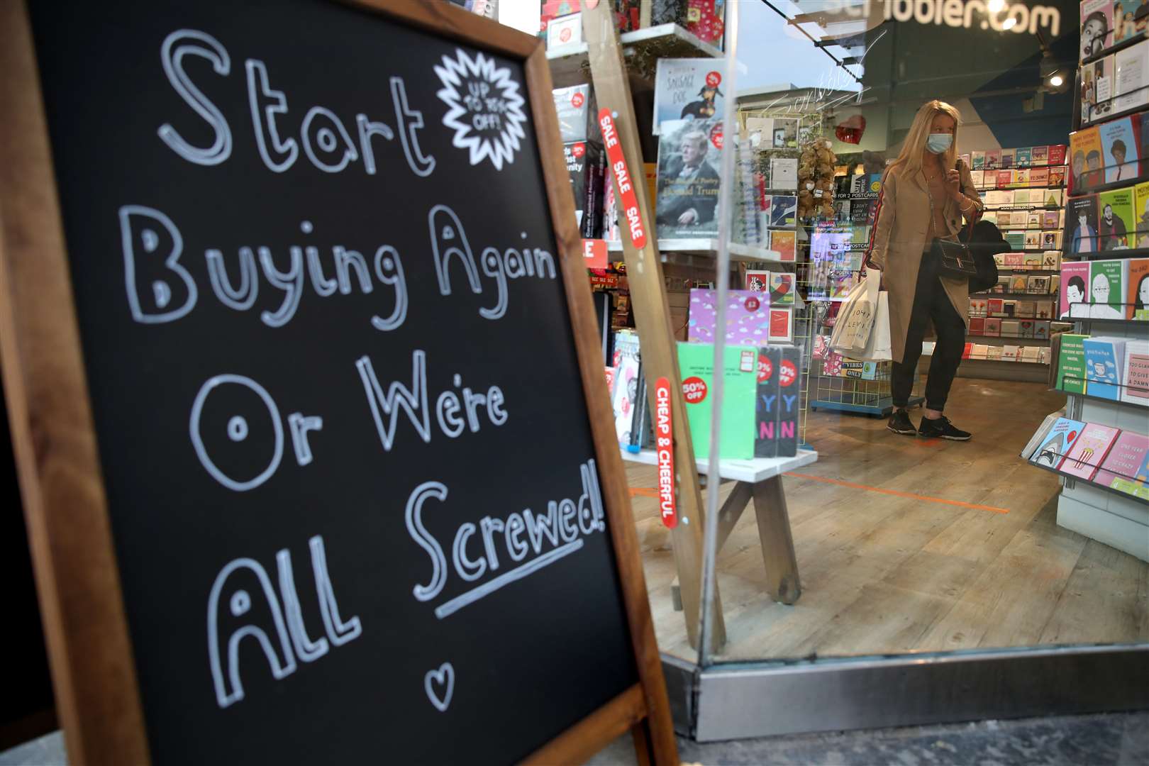 A notice on a billboard encourages customers to help keep firms in business in Glasgow city centre (Andrew Milligan/PA)