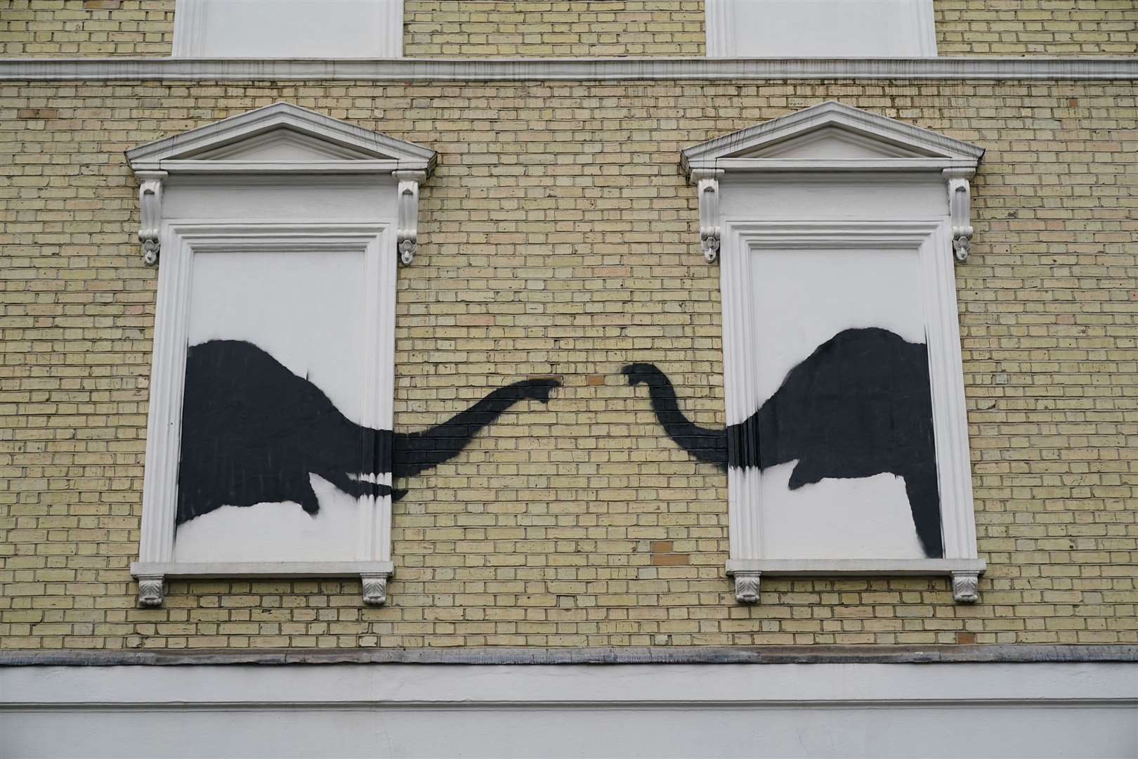 A new artwork depicting two elephants poking their heads out of blocked out windows appeared on the side of a building in Chelsea (Yui Mok/PA)