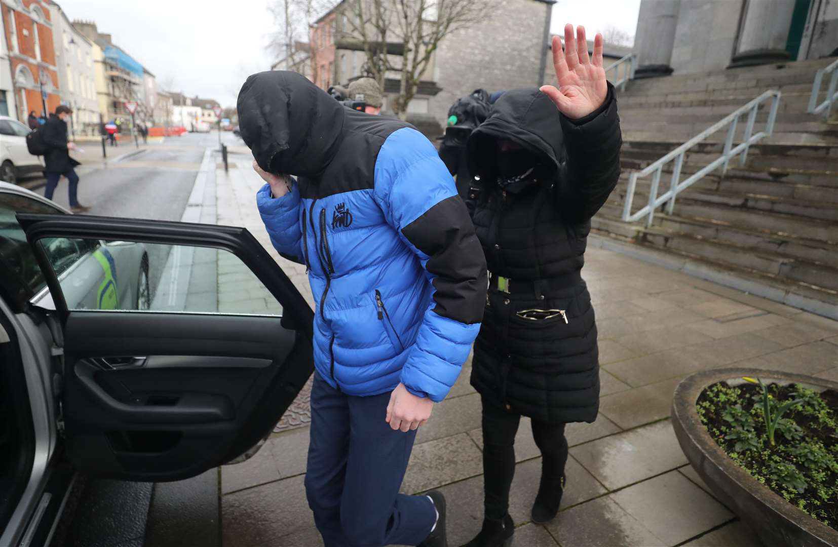 Patrick O’Brien (left) covers up as he leaves Tralee District Court where he escaped a criminal conviction (Niall Carson/PA)