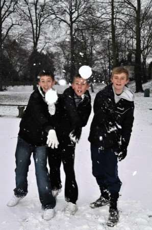 This pic: Andy and Joshua Judd, seven, make their way across The Grove to Grove Park Primary School, one of the few open.