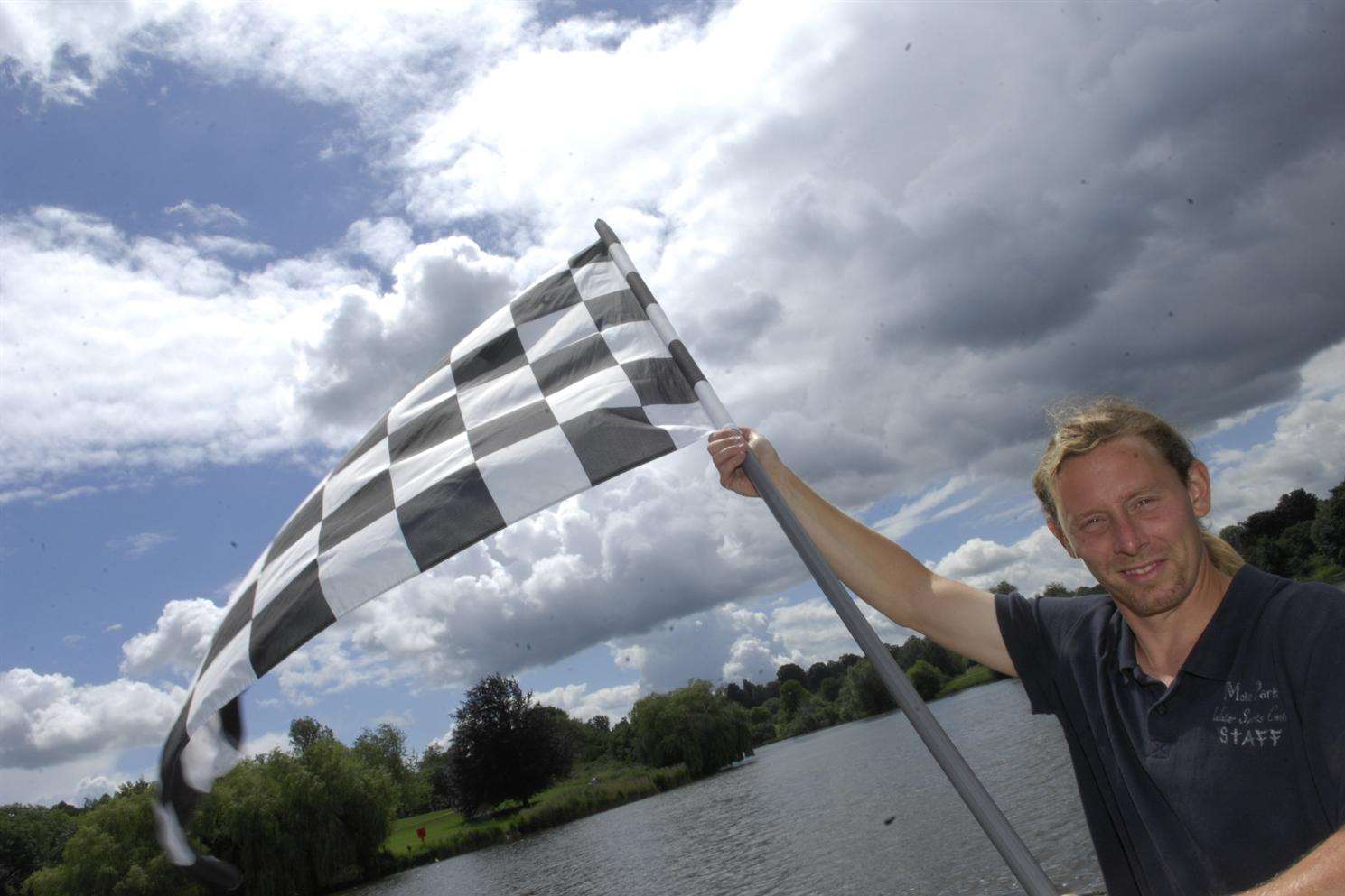 Stuart Clarke of Mote Park Water Sports Centre waves the starter flag for last year's KM Dragon Boat Race. Mote Park once again provides the setting for this event which is a highlight of the summer.