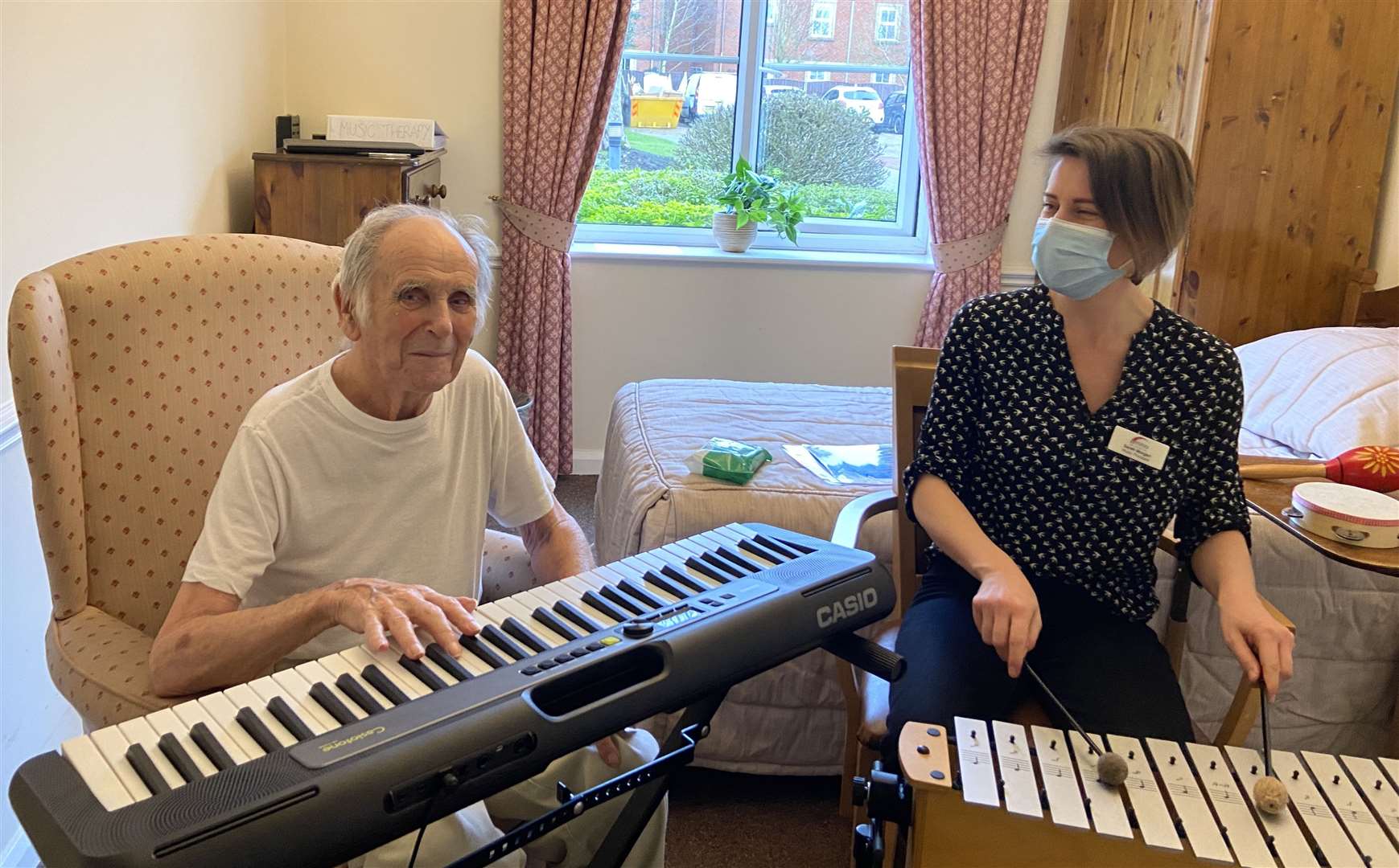 Resident Dennis Holman with music therapist Sarah Morgan (MHA/Casio/PA)