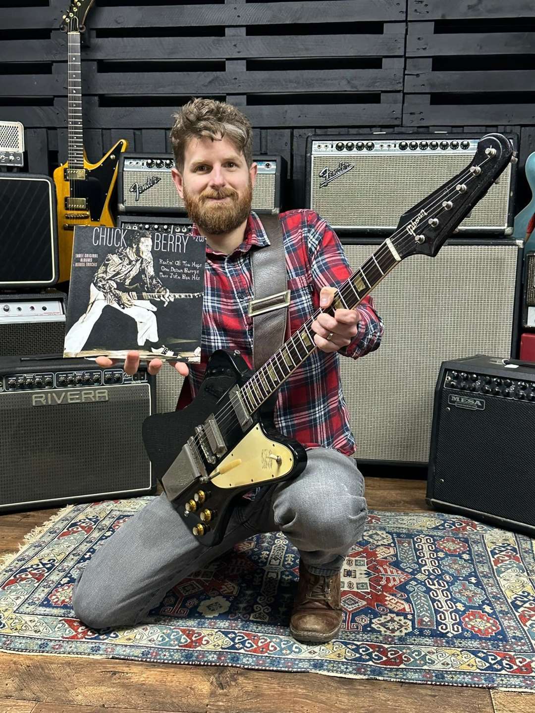 Auctioneer Luke Hobbs posing with Chuck Berry’s guitar (Gardiner Houlgate/PA)