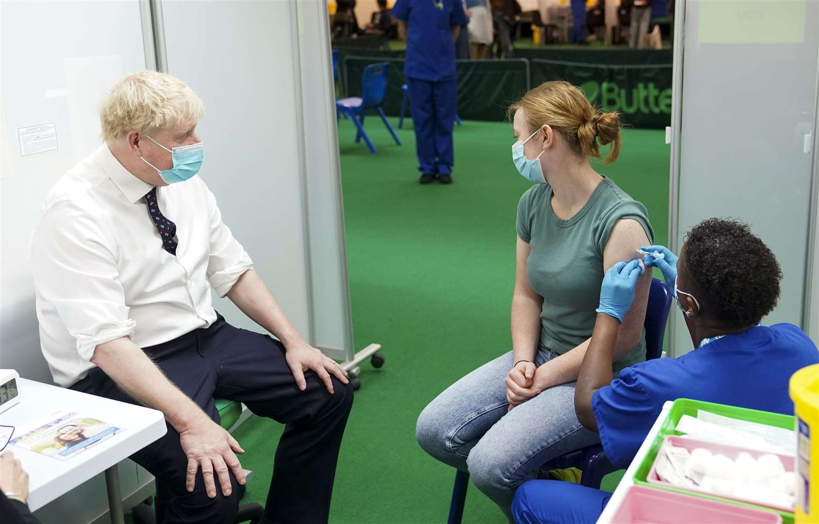 Prime Minister Boris Johnson watches as a teenager receives her Covid-19 booster vaccine (Steve Parsons/PA)