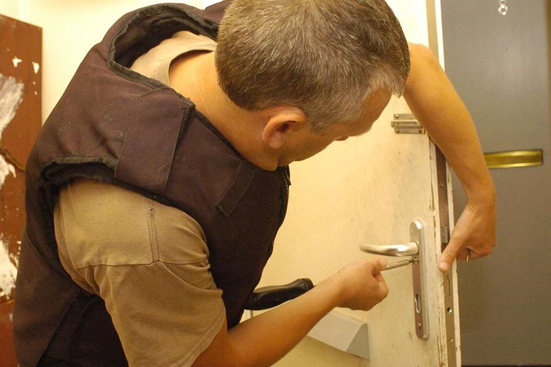 An officer enforces a crack house notice. Library image