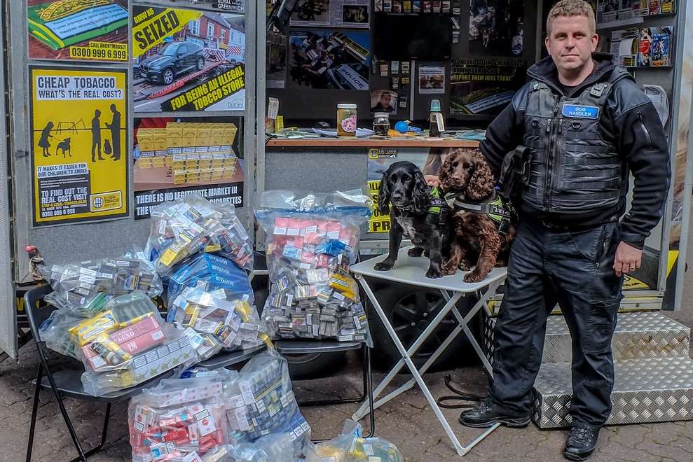 Sniffer dogs Phoebe, black, and Yoyo, brown, with handler Stu Phillips and the tobacco found in Gravesend. Picture: BWY Canine Ltd