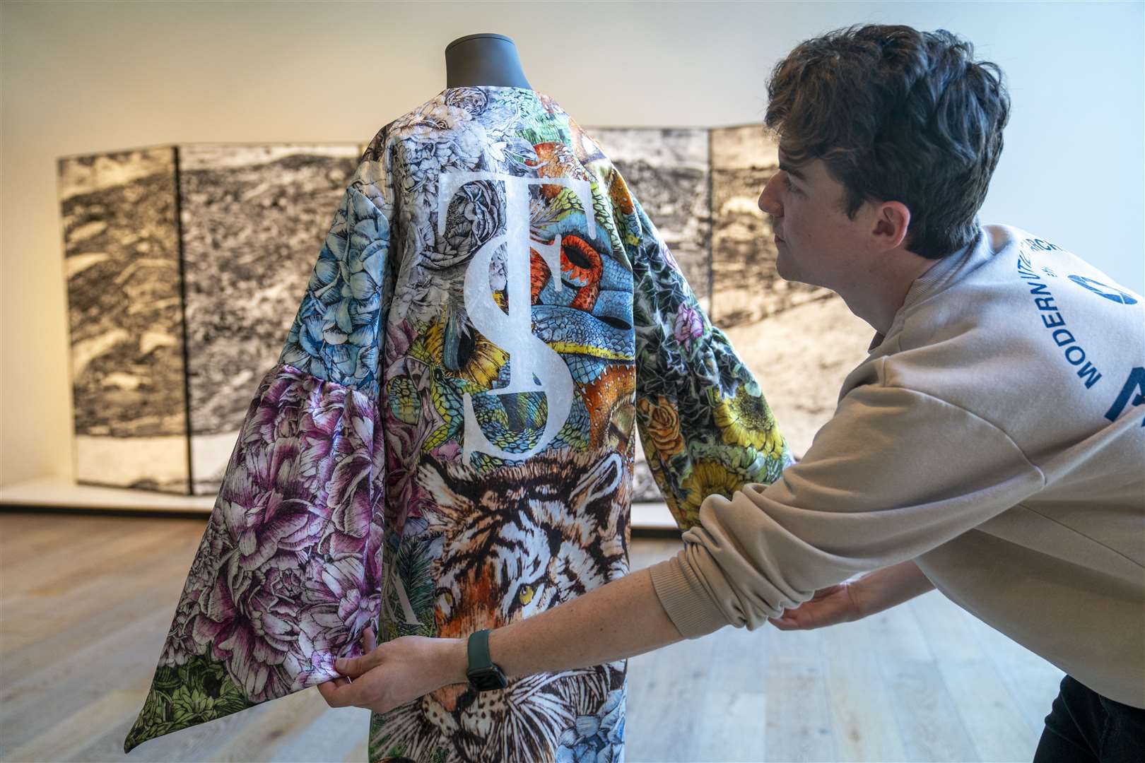 Museum content manager Chris Keatch examines the kimono inspired by Taylor Swift’s albums (Jane Barlow/PA)