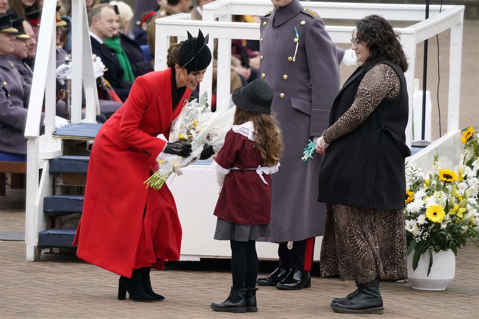 Kate is presented with a bouquet of flowers by a young girl in traditional Welsh costume (Andrew Matthews/PA)