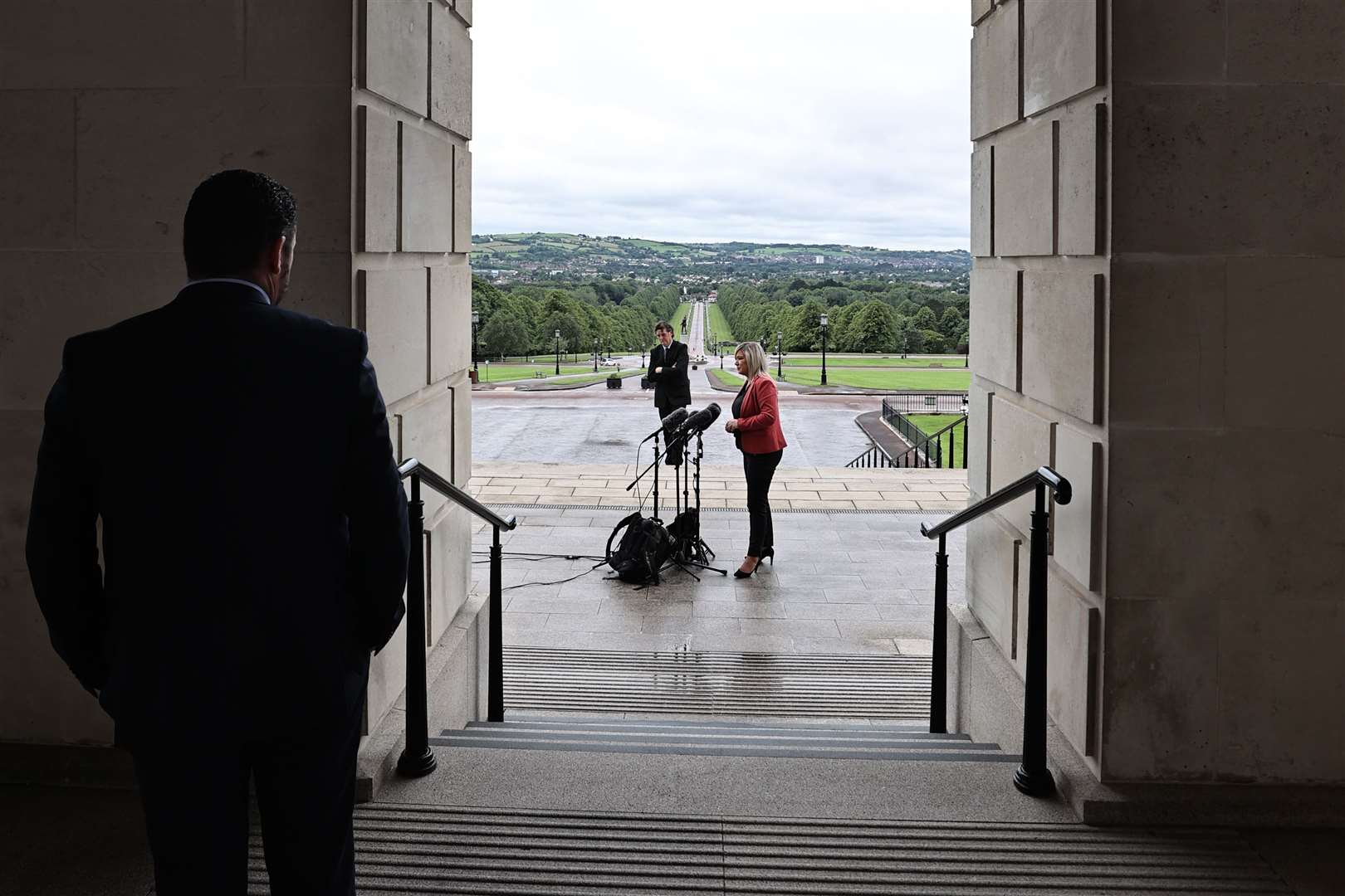 Sinn Fein press officer Sean Mag Uidhir looks on as then-deputy first minister Michelle O’Neill takes part in a press conference outside Parliament Buildings in Stormont, Belfast in 2020 (Liam McBurney/PA)