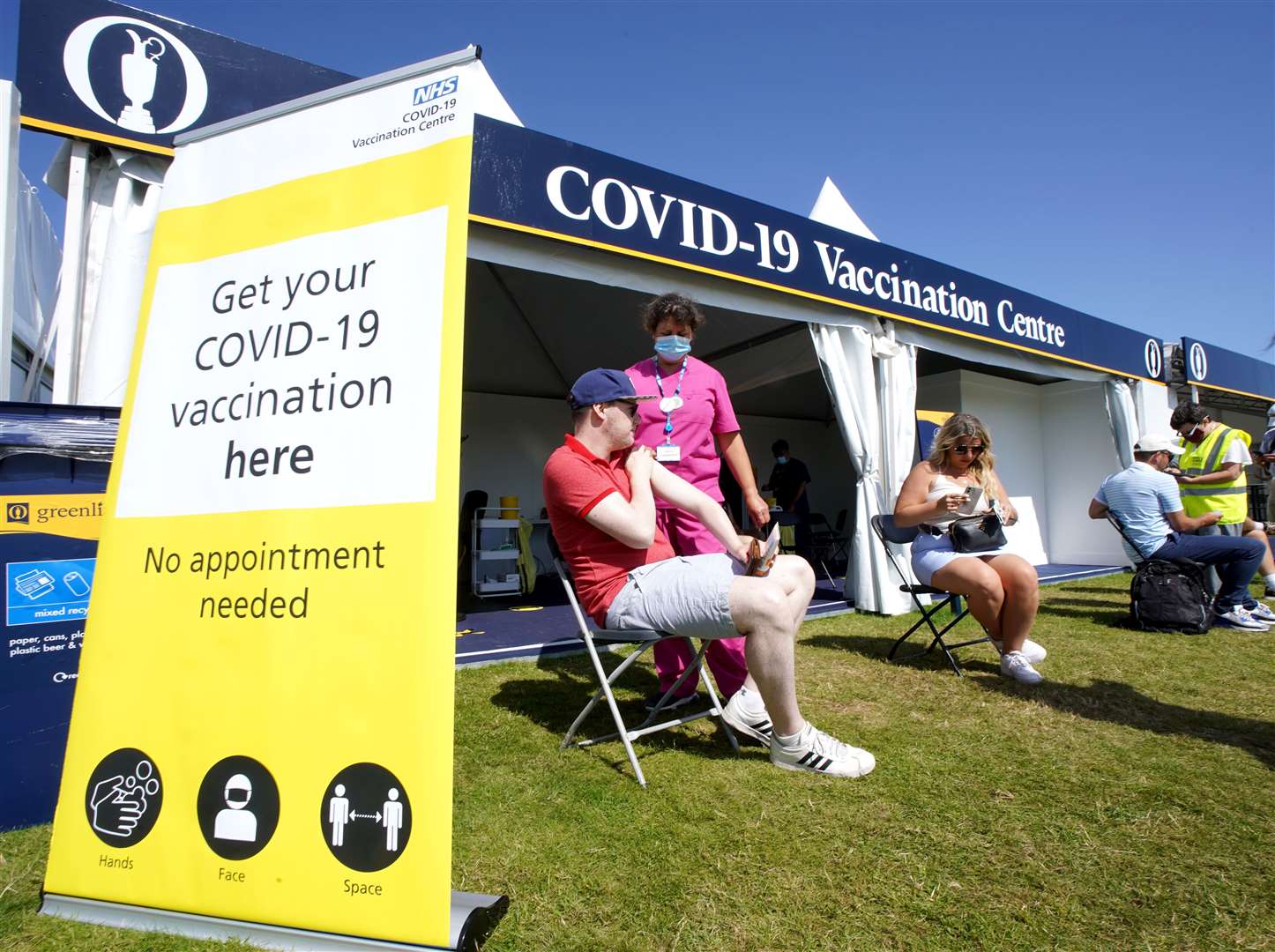 Members of the public get their Covid-19 vaccination between holes (Gareth Fuller/PA)