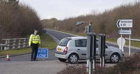A police officer mans the cordon set up on the A28 at Great Chart. Picture: GARY BROWNE