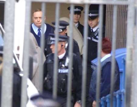 Two of the suspects, covered in blankets, being escorted by police to a prison van after the court hearing. Picture: GRANT FALVEY