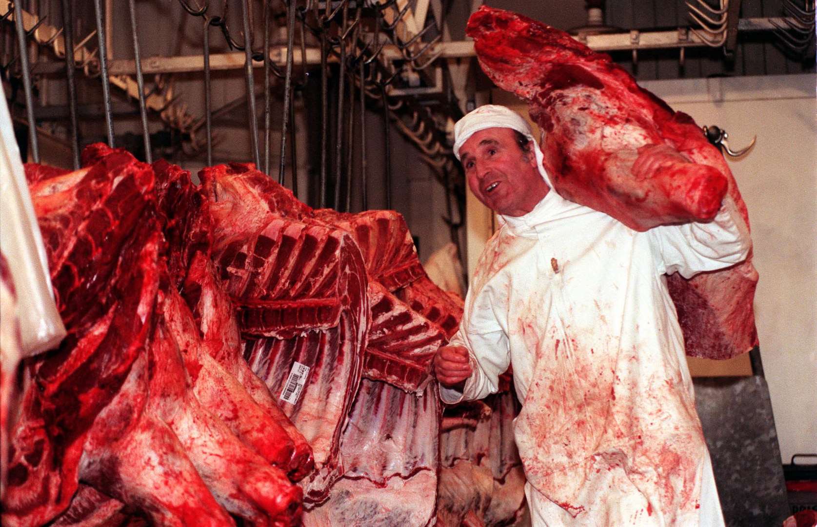 A Smithfield market butcher at work among beef carcasses (Fiona Hanson/PA)